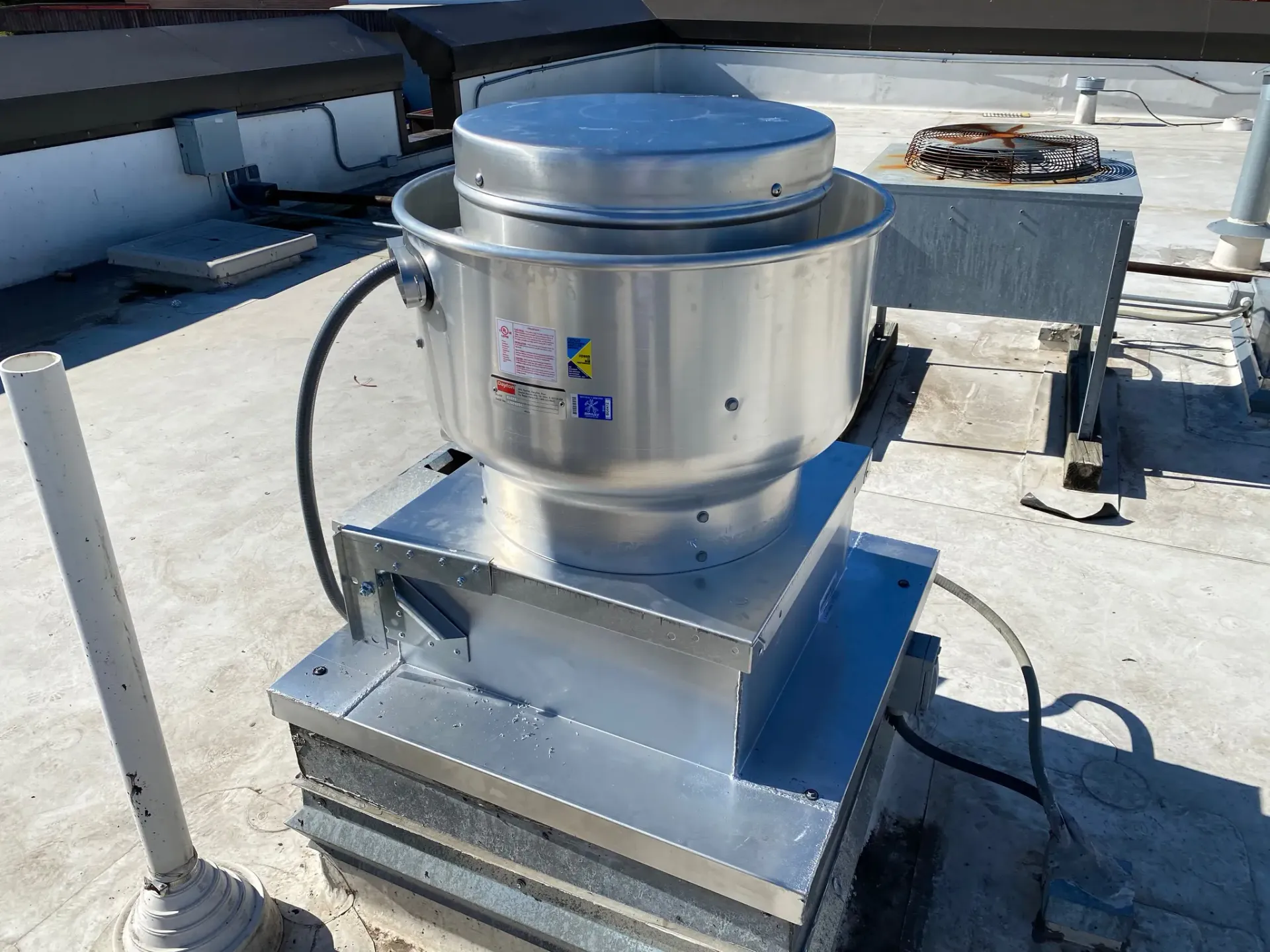 Commercial rooftop exhaust fan installed on a curb